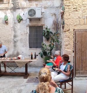 grupa ludzi siedząca przy stole i jedząca jedzenie