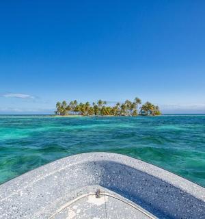 a boat in the ocean with an island in the distance