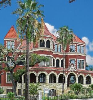 一座红色的大楼,前面有棕榈树