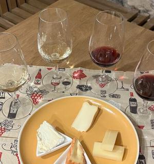 桌子上摆着一盘奶酪和几杯酒