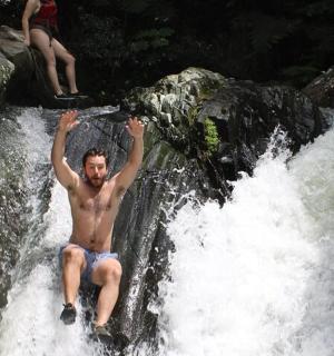 muž sedící na vrcholu vodopádu