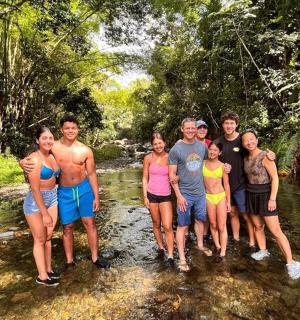 skupina lidí pózujících pro fotografii v řece