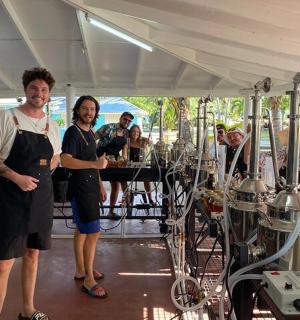 一群人站在摆着酒架的房间里