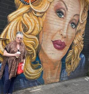 žena stojící před zdí s nástěnnou malbou