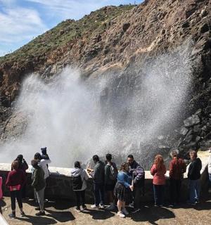 a group of people standing in front of a waterfall