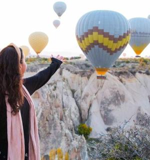 一名女子正在仰望热气球