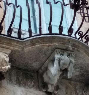 a statue of a person under a balcony