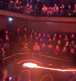 a crowd of people in an auditorium watching a show