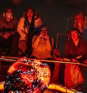 a group of people sitting in front of a fire