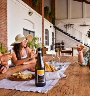 三个人坐在一张桌子旁,手里拿着一瓶酒