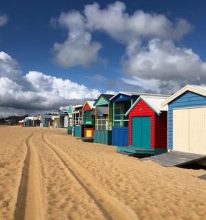 řada barevných plážových chatrčí na pláži