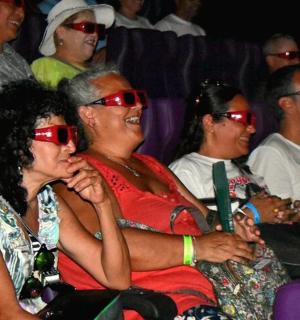 קבוצת אנשים יושבת בקהל ועונדת משקפי שמש