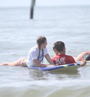 skupina lidí jezdících na surfových prknech ve vodě