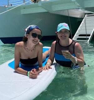 two people are sitting on a surfboard in the water