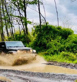 ein Jeep, der durch eine schlammige Straße fährt