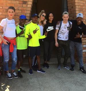 一群人站在砖墙旁边