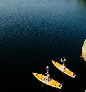 Dva lidé stojí na surfových prknech ve vodě