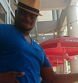 muž v klobouku držící červený deštník