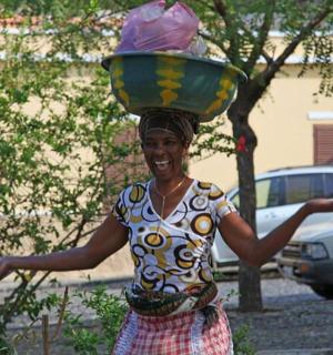 a woman is carrying a pot on her head