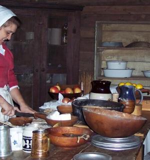 žena připravující jídlo v kuchyni s dítětem