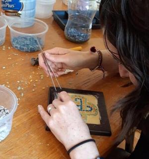 一位女士坐在桌边，手里拿着手机