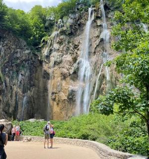 a group of people standing in front of a waterfall