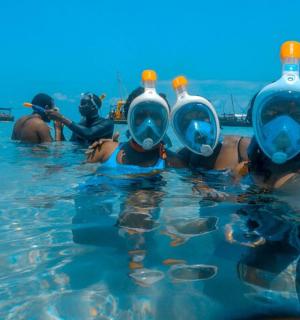 一群人在水中，头上顶着瓶子