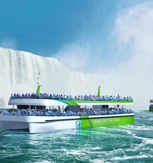 skupina lidí na lodi před vodopádem