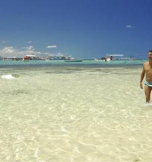 two people standing in the water on a beach