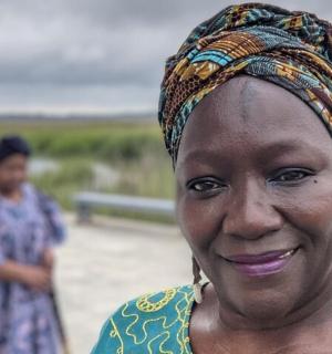 a woman wearing a headdress smiles at the camera