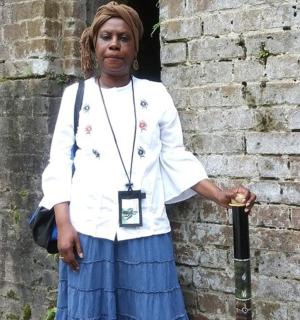 žena stojí před cihlovou zdí