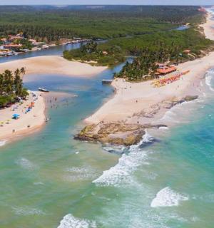 an aerial view of a beach with people in the water