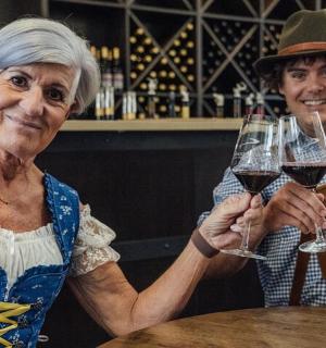 一位年长的妇女拿着两杯酒