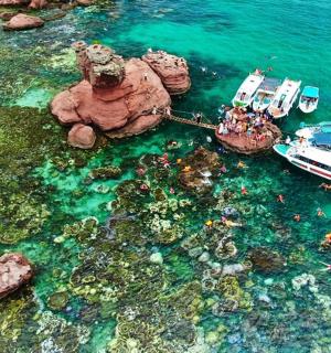 two boats are docked in the water next to rocks
