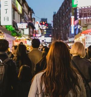 dav lidí jdoucích po rušné městské ulici