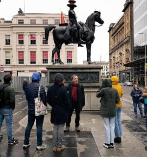 一群人站在一尊骑马男子的雕像周围