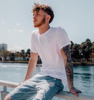 一名男子坐在水边的栏杆上