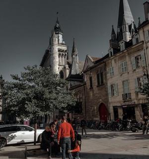 一群人在一座钟楼所在的城市街道上