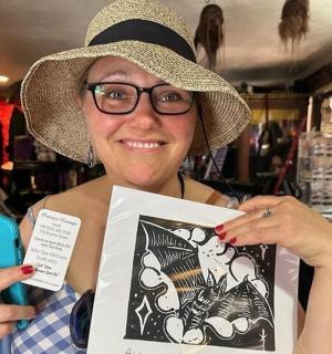 a woman wearing a hat holding up a picture