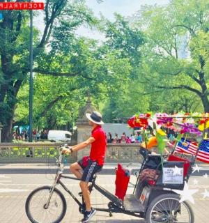 a man riding a bike with a cart