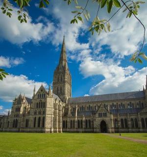 a large building with a tower and a grass field