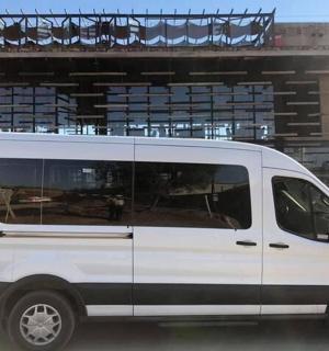 bílá dodávka zaparkovaná před budovou