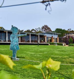 socha ženy stojící na travnaté louce