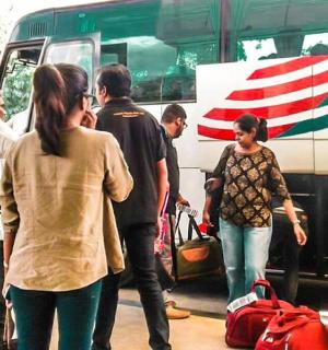 a group of people standing outside of a bus