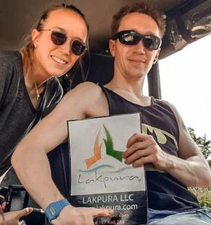 a woman sitting next to a man holding a sign