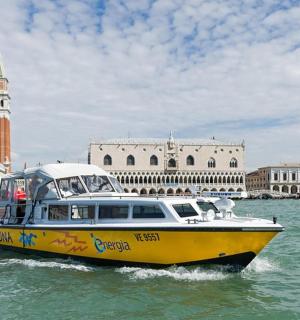 Žlutá a bílá loď ve vodě poblíž města