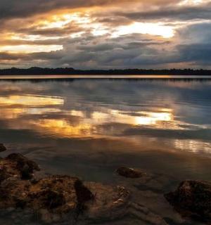 a large body of water with a cloudy sky