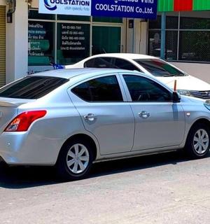 a silver car parked in front of a store