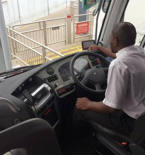 一名男子坐在公交车驾驶座上