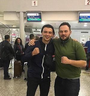 zwei Männer posieren für ein Foto auf einem Flughafen